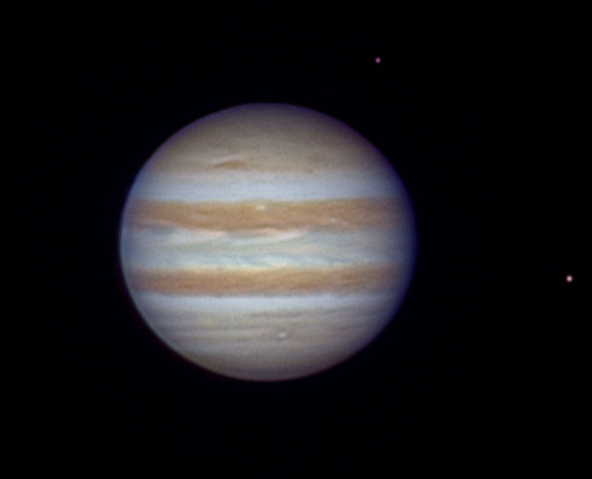 High-resolution image of Jupiter with Europa and io visible, showing atmospheric cloud bands and orbital alignment. 
